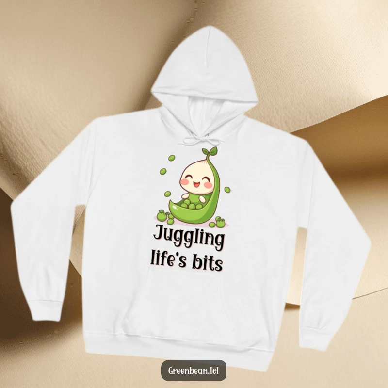 Funny hoodie illustration of a green bean segment juggling peas, representing focus and lighthearted skill.